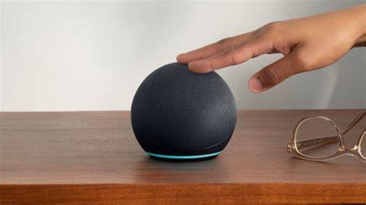 Echo Dot 2020 fourth generation in hand showing controls Fourth-gen Echo Dot in hand